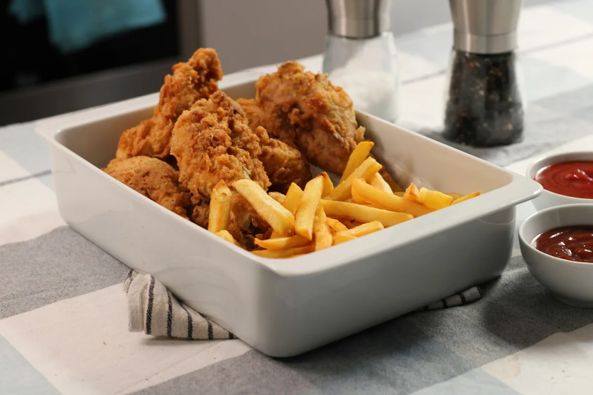 Close-up of a plate holding golden fries next to a dish of ketchup