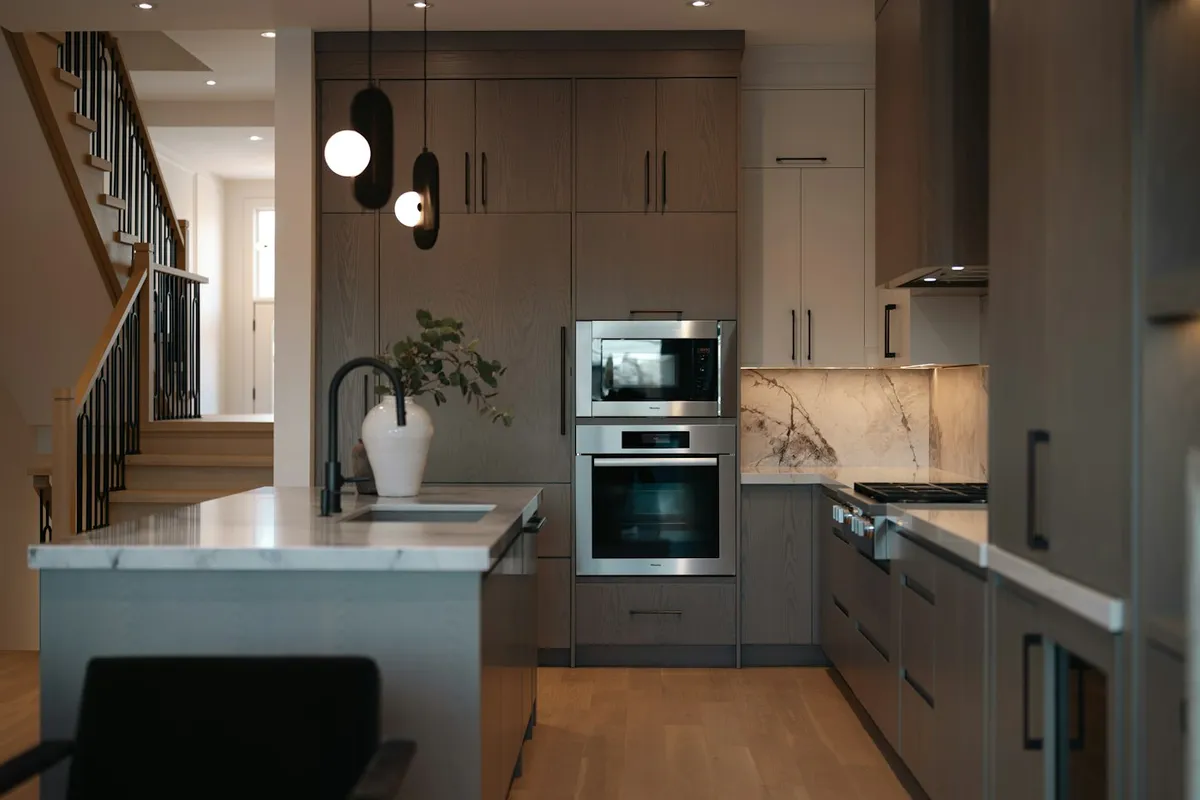 A modern kitchen with grey cabinets and stainless steel appliances