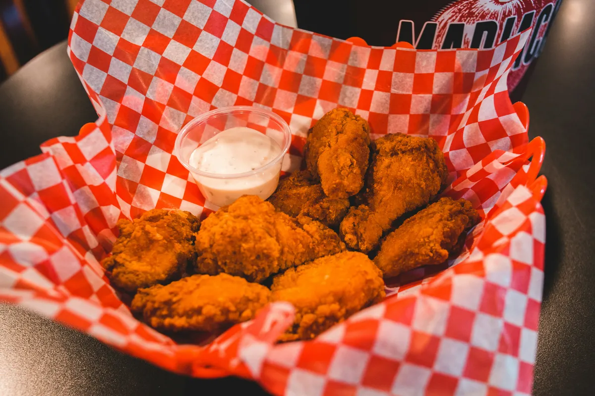 Fried chicken piled on a white plate, crust still crackling