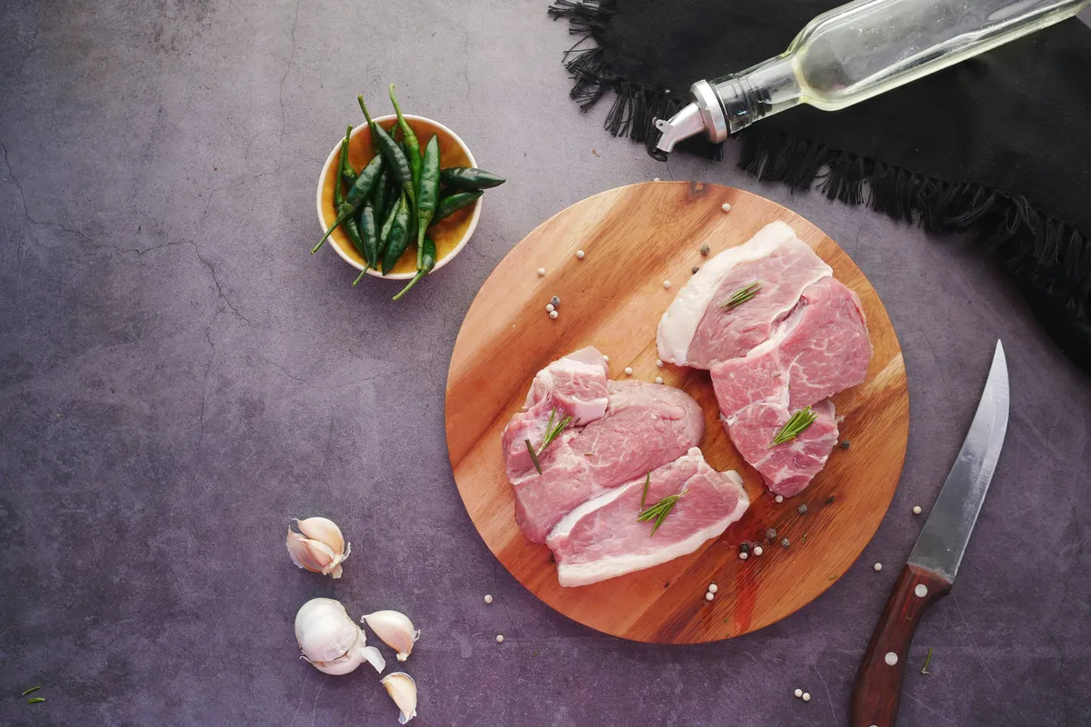 Raw chops laid out on a board before any seasoning goes on