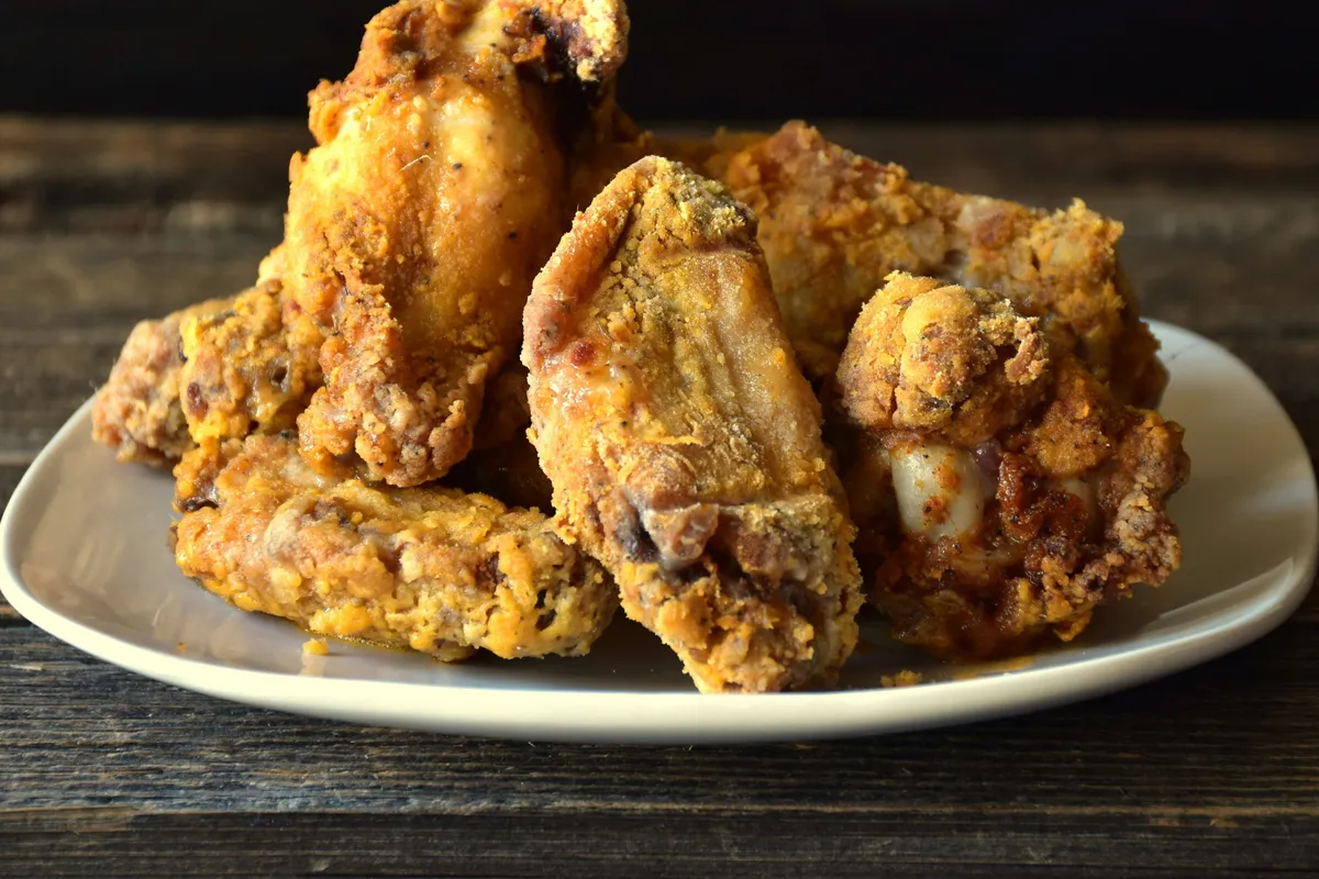 Golden chicken pieces heaped on a plate straight from the heat