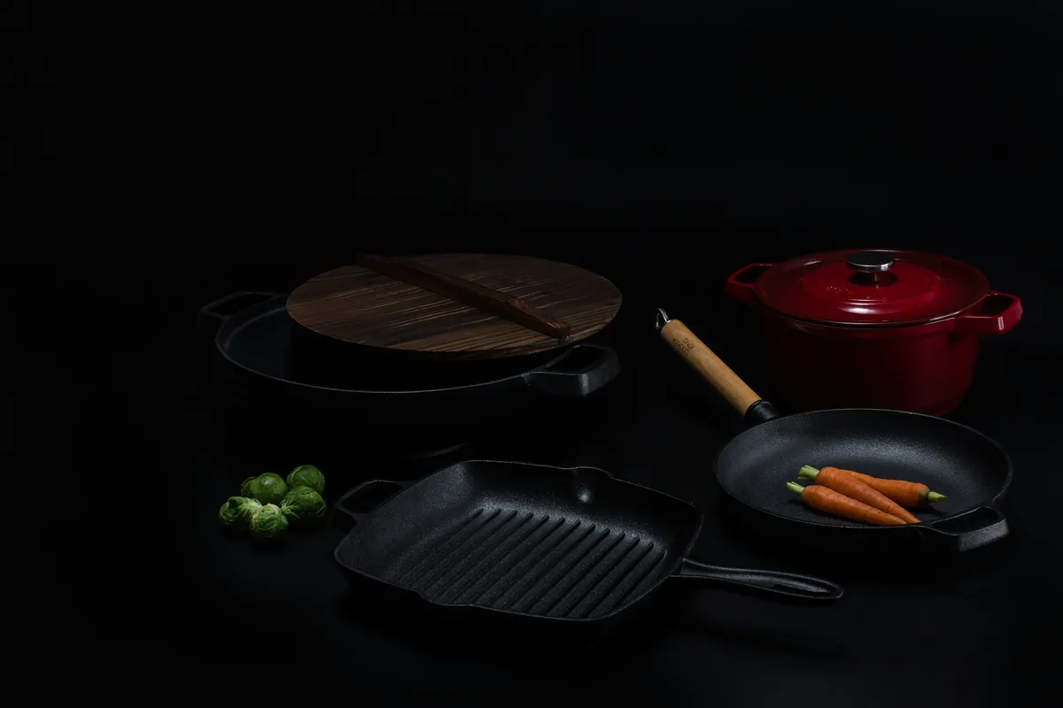 A dark frying pan beside a round chopping board, ready to work