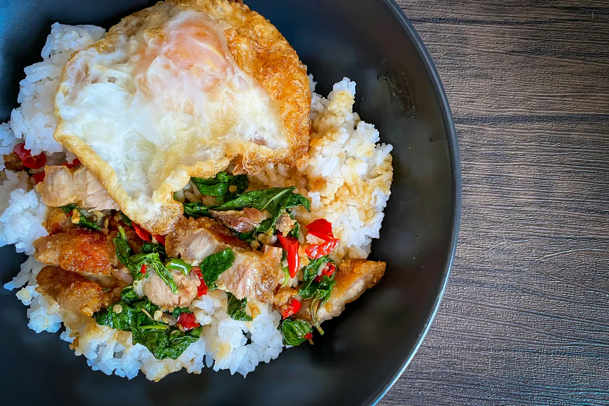 Stir-fried basil and rice plated the way a Bangkok stall sends it out